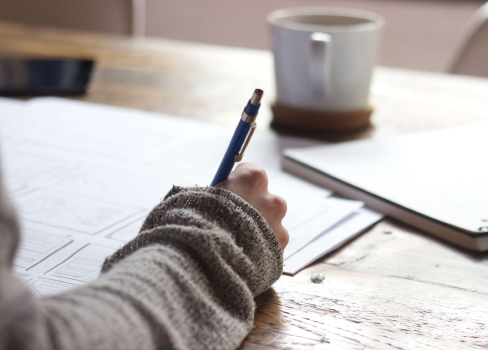A person writing on a piece of paper.